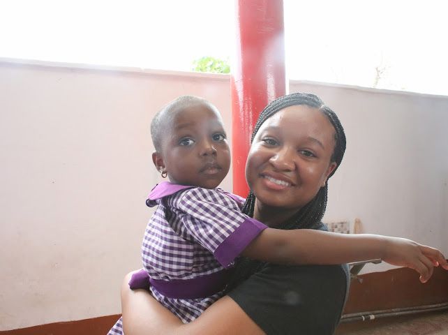 Zuriel holding a child in Ghana