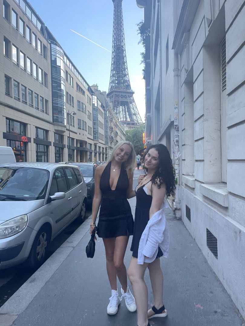 Two students in Parisian alley with Eiffel Tower in background