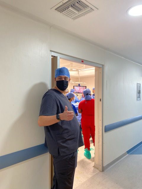 Adam giving a thumbs up as he stands outside an operating room in Mexico