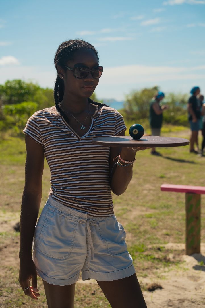 Lauriel holding a pool ball on a round wooden platter