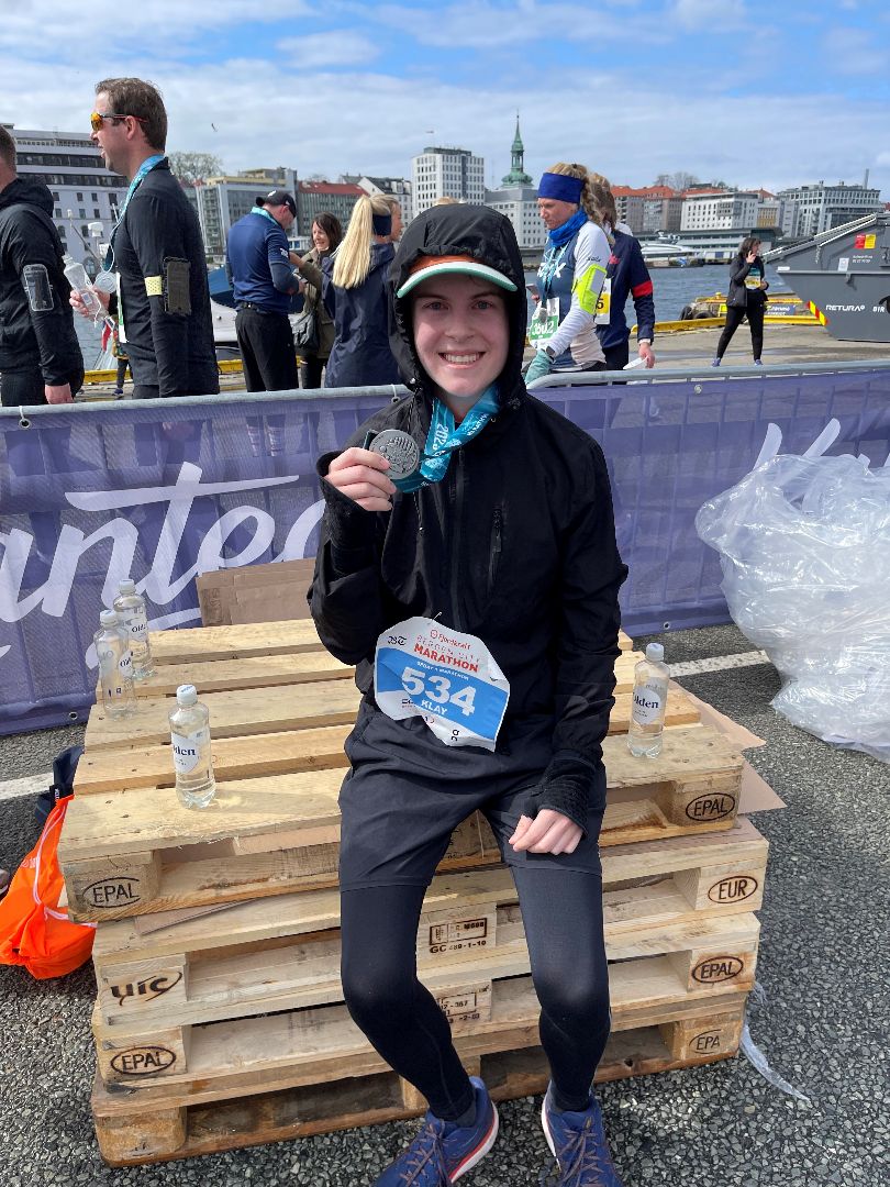 Klay holding marathon medal in Norway