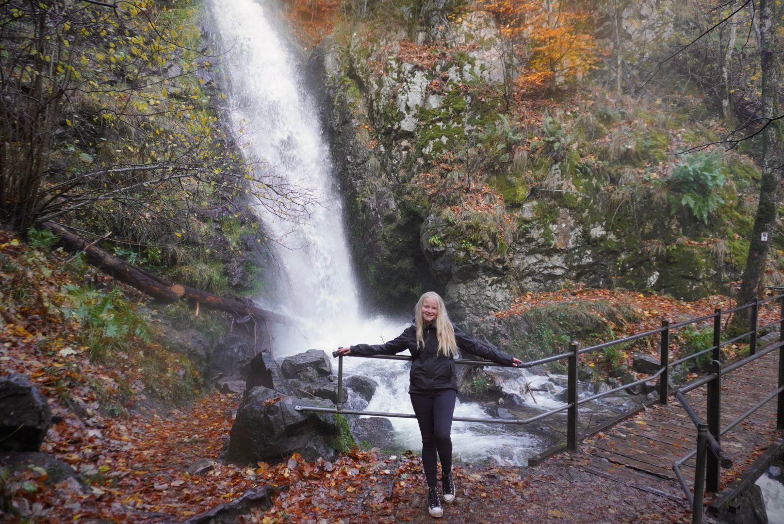 Lariah standing at the base of a waterfall in Northern Ireland