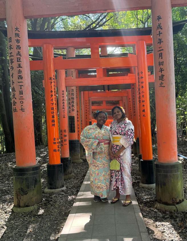 A’Lvinia and friend wearing traditional Japanese robes in a large orange temple