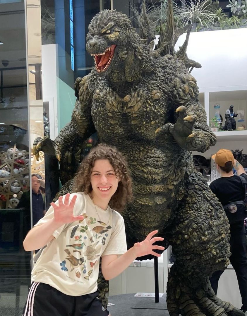 Cadence posing in front of a godzilla statue