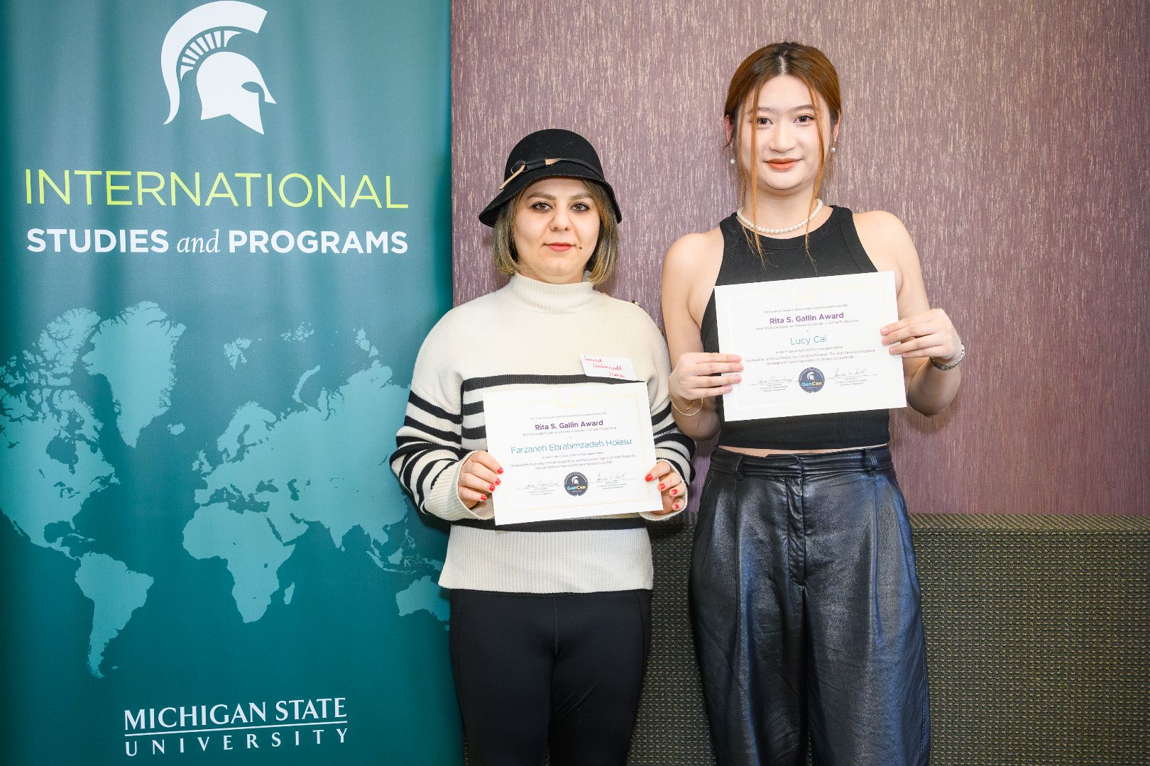 Farzaneh and Lucy smiling with their award certificates