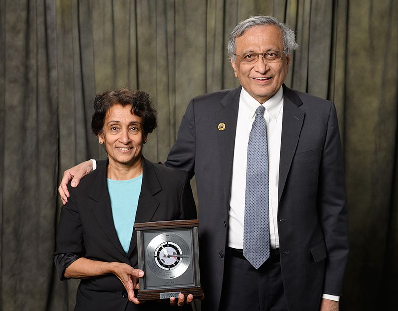 Lalita Udpa holding award while standing with Satish Udpa, Acting President of MSU