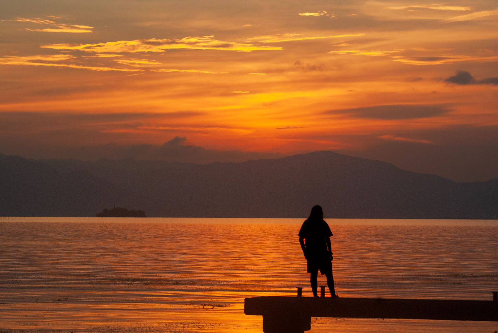 The silhouette of Felix on a dock with the sunset