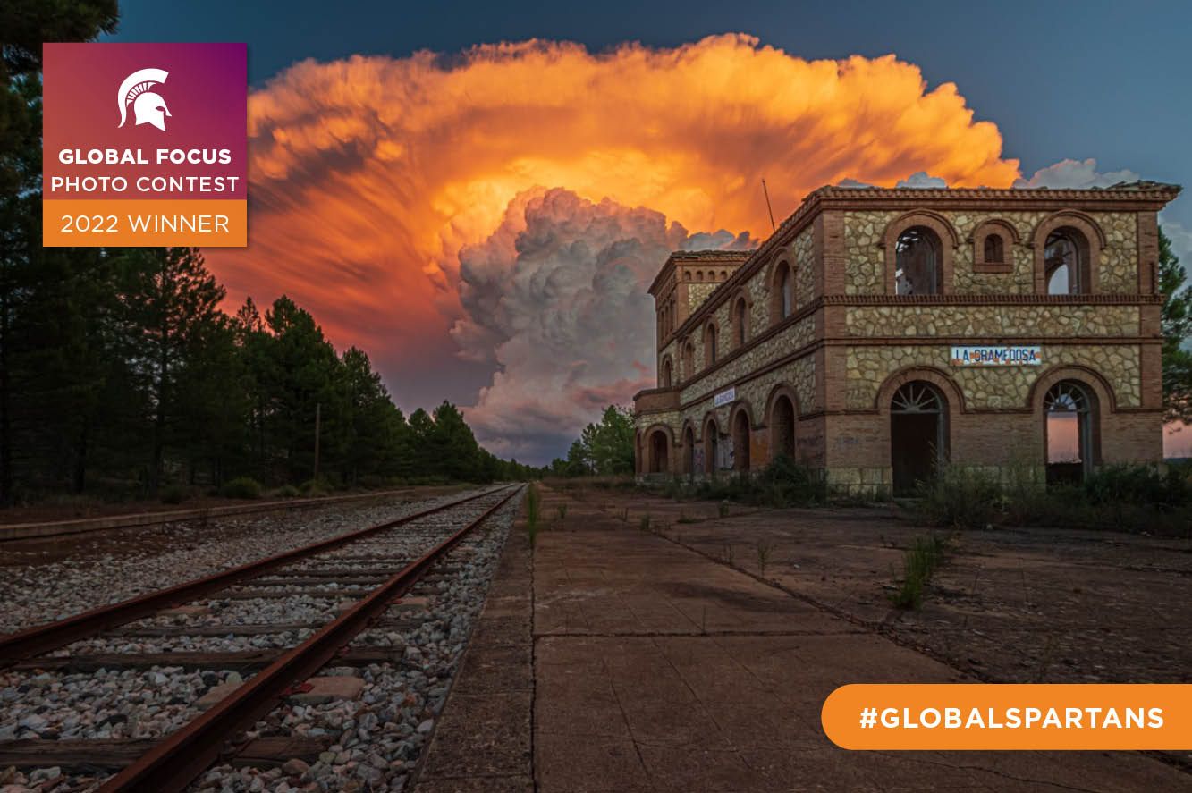 An abandoned train station with a swirling cloud formation in the background.