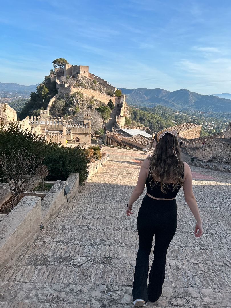 Caitlin walking on cobbleston path down a mountain in Spain