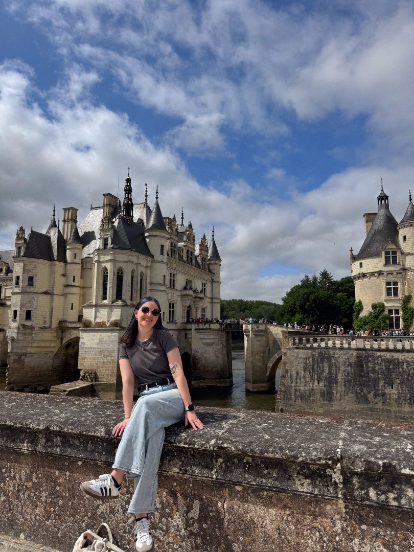 Elizabeth sitting on a wall in front of the Château de Tours