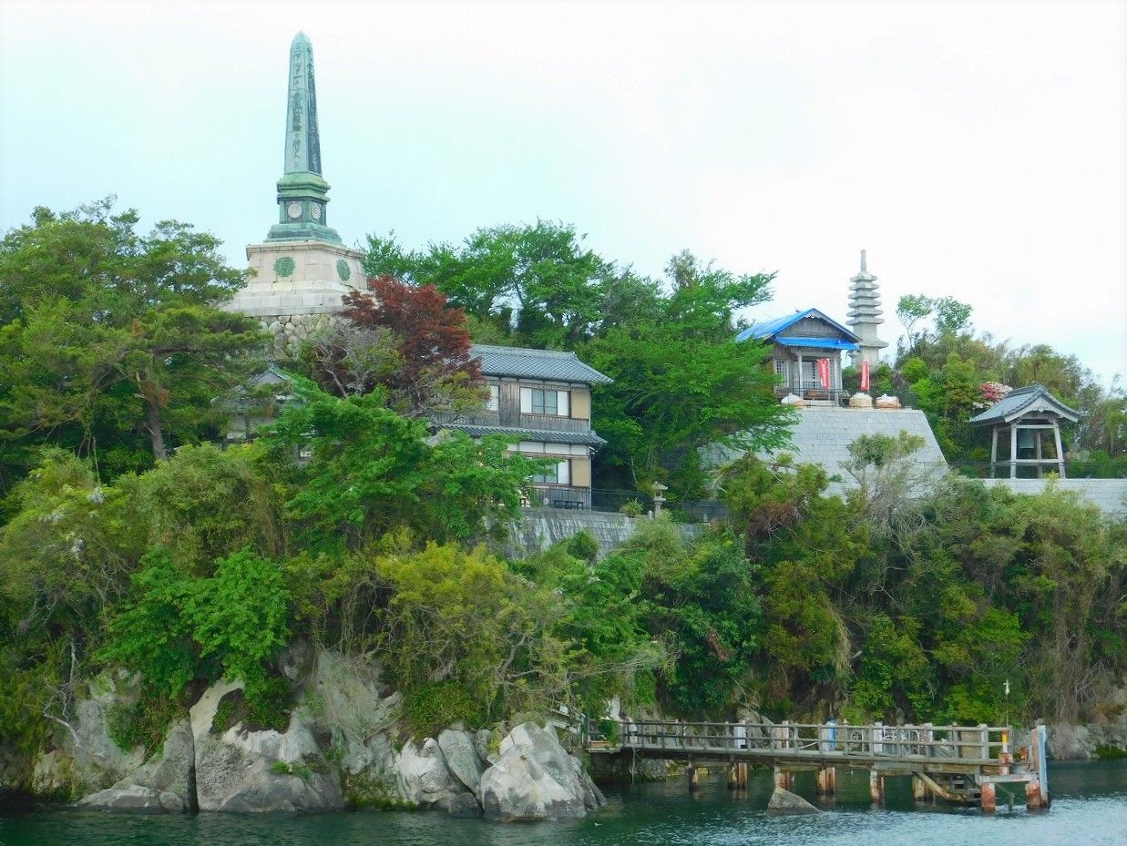 a small rocky island with trees and a temple