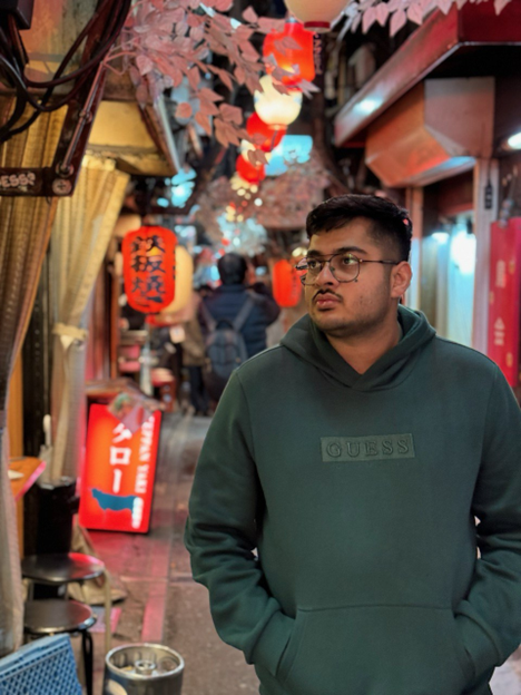 Mustafa in a colorful merchant ally at night in Japan