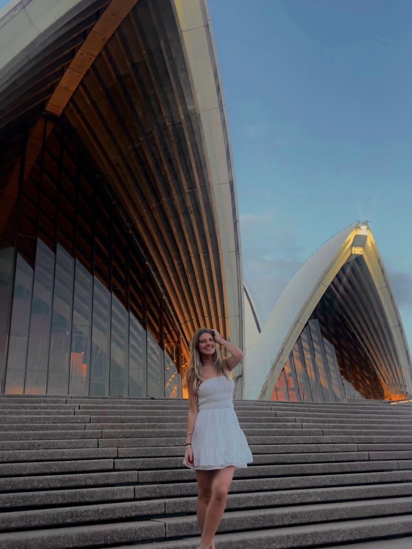 Mackenzie standing in a white dress in front of the Sydney Opera House
