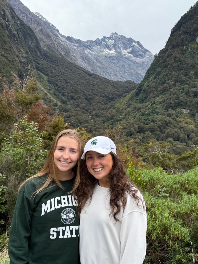 Olivia and friend wearing MSU attire in the mountains of New Zealand