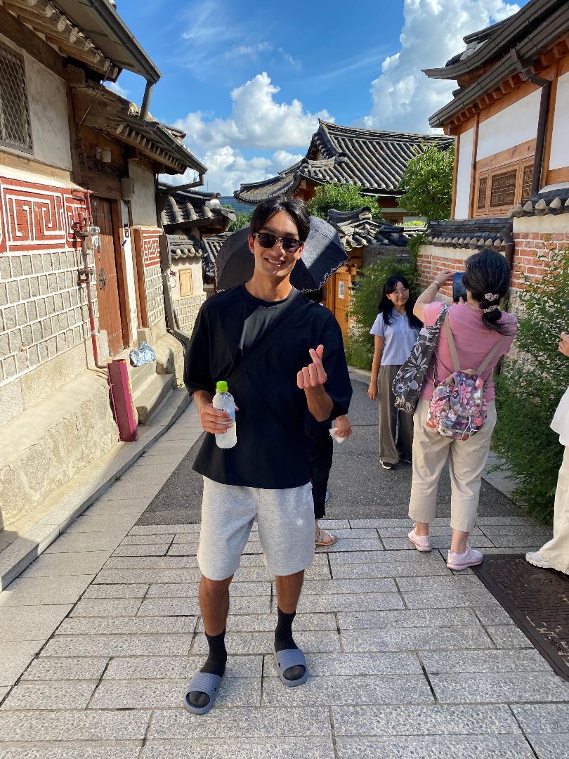 Emad wearing sunglasses standing on a small street in S Korea