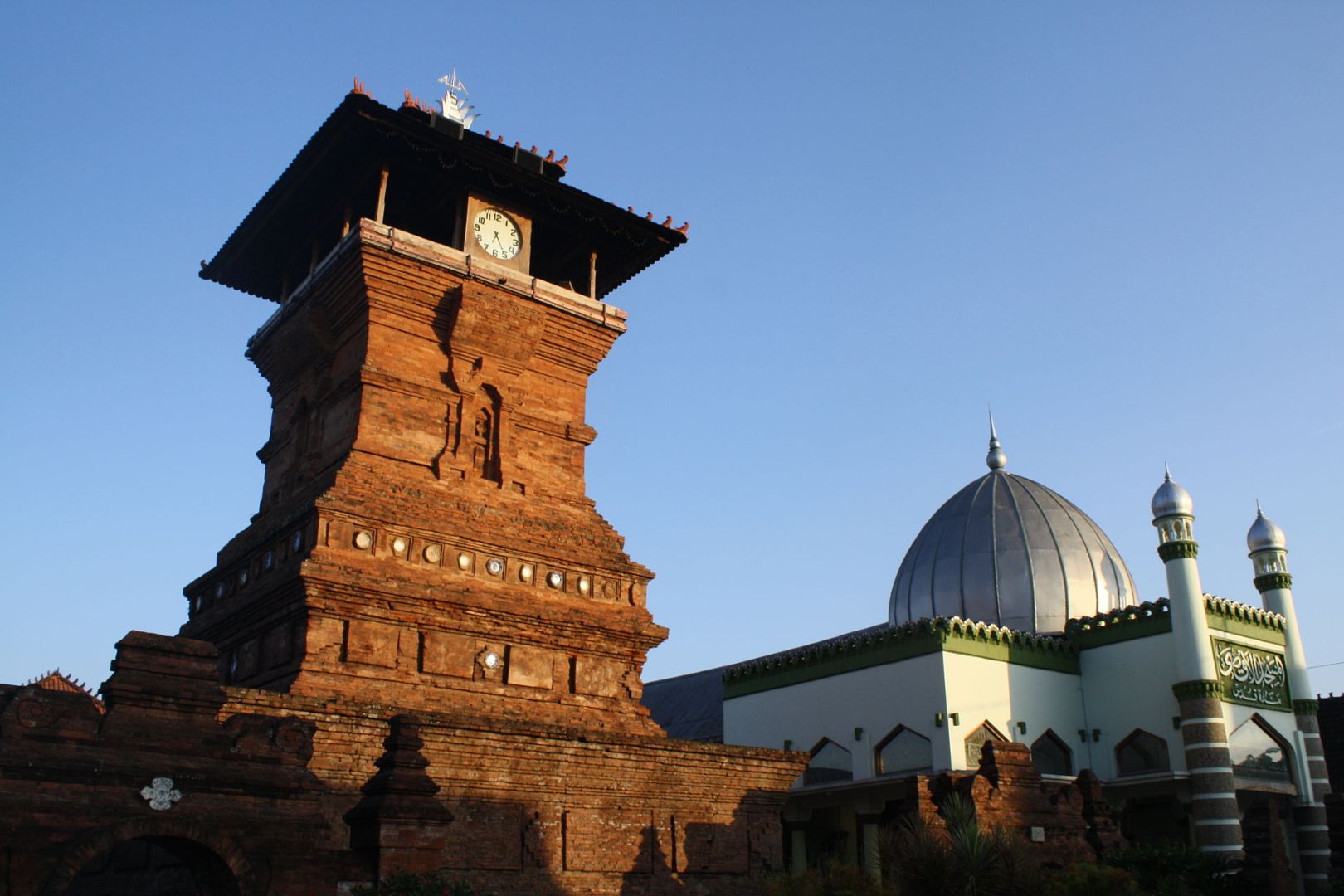 A mosque featuring pre-Islamic architectural forms such as old Javanese split doorways, ancient Hindu-Buddhist influenced Majapahit-style red brickwork, and a three-tired pyramidal roof.