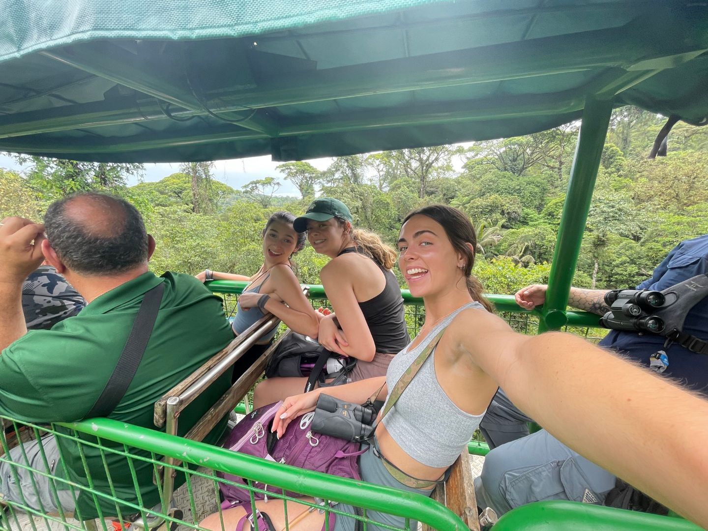 Elizabeth taking selfie with other students while riding in a vehicle through rainforest