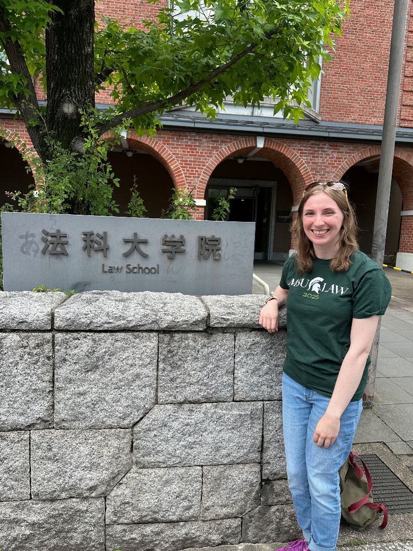 Catherine standing next to sign of Japanese Law School