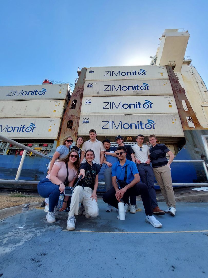 Group of students posing in front of shipping containers at the Panama Canal