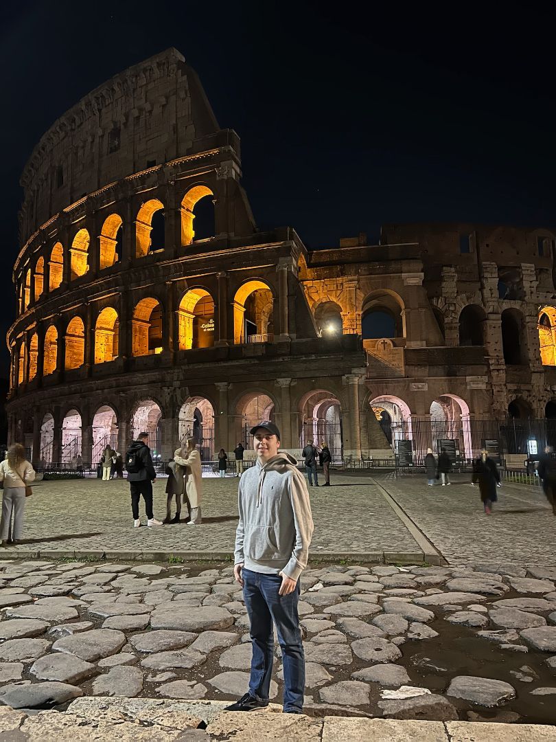 Kyle standing in front of the colesium in Rome at night