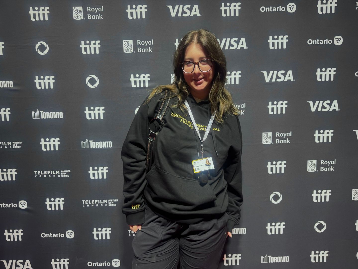 Caitlyn posing in front of a TIFF background