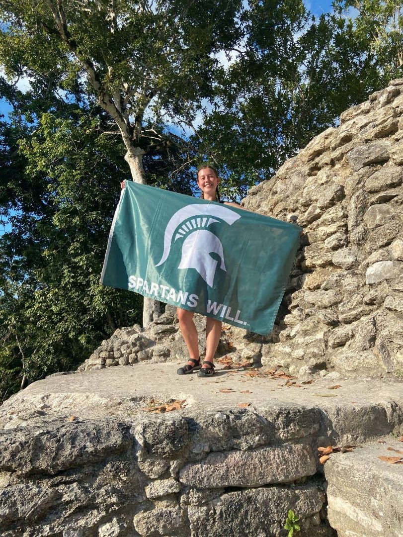 Bella holding a Spartan flag in Belize