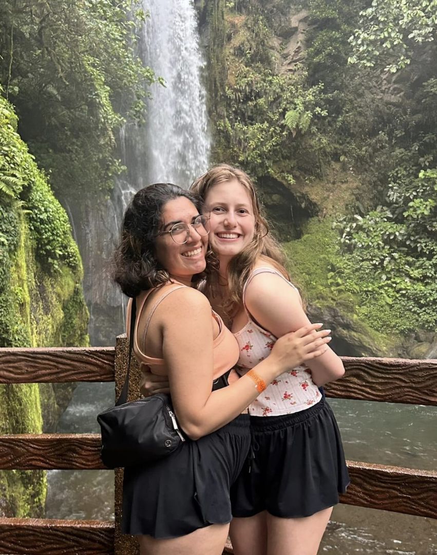 Monika and friend posing in front of a waterfall in Costa Rica