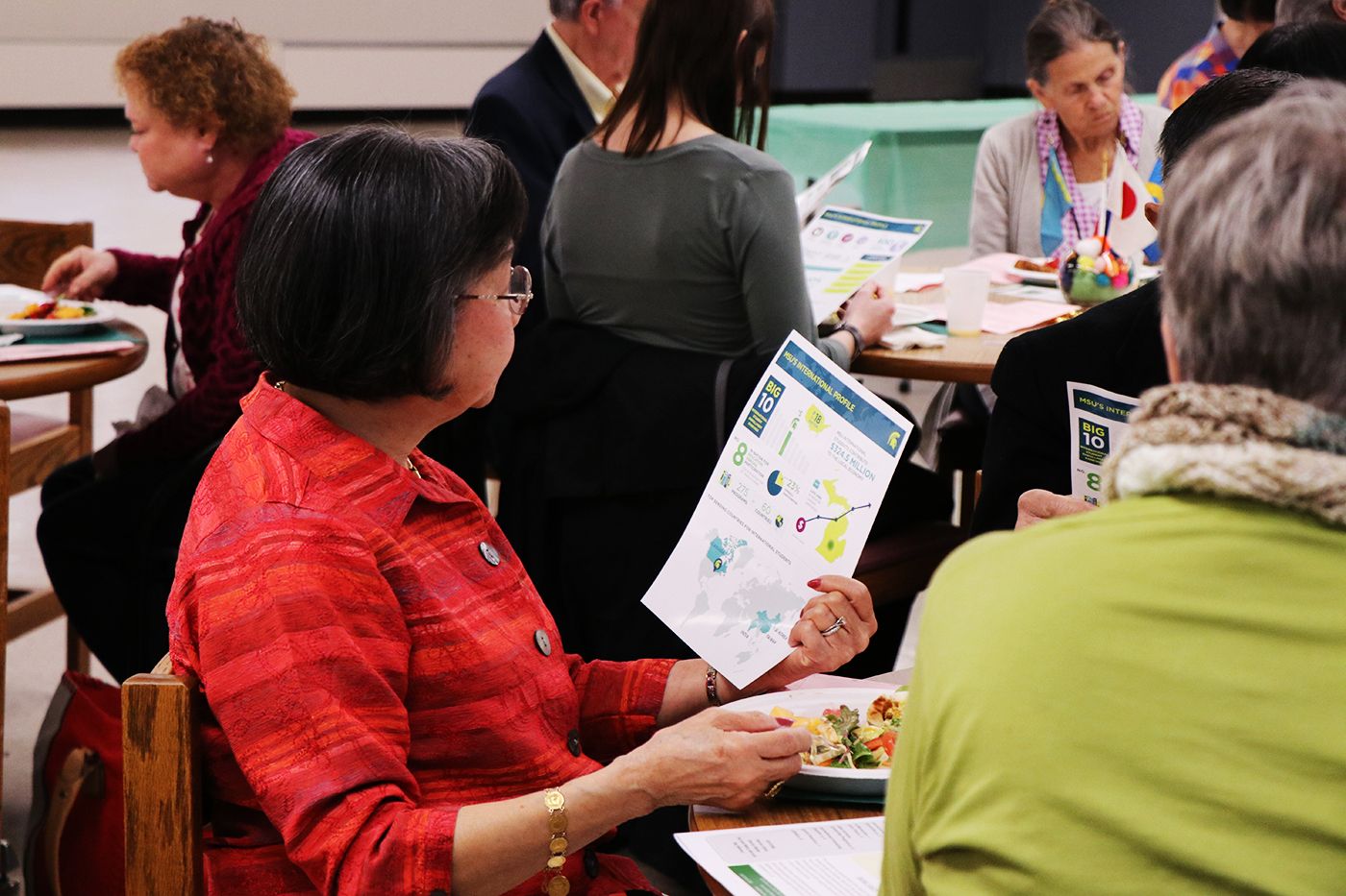 Audience member reading pamphlet during luncheon