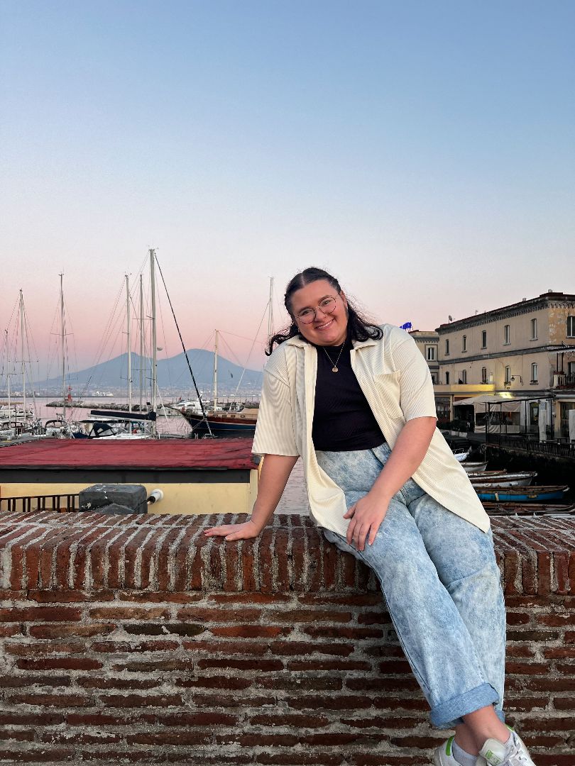 Jenna sitting on a brick wall in Italy