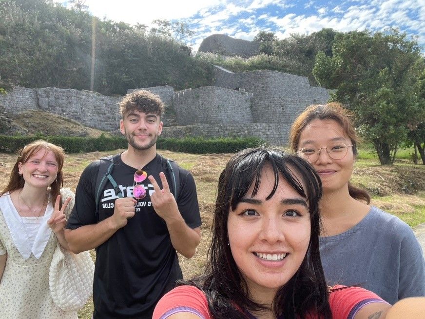 Alex giving peace symbol in Japan with three friends 