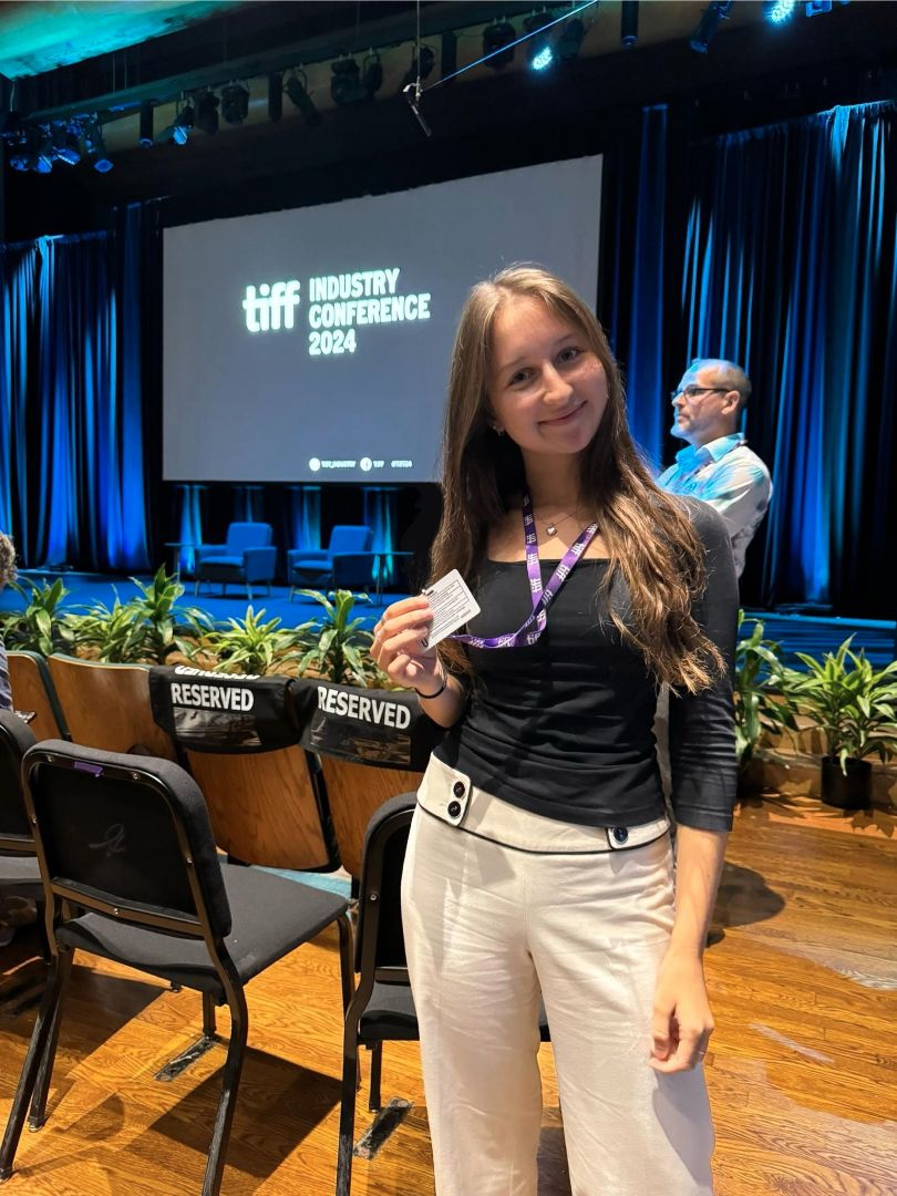 Klaudia showing off her industry pass inside a conference room