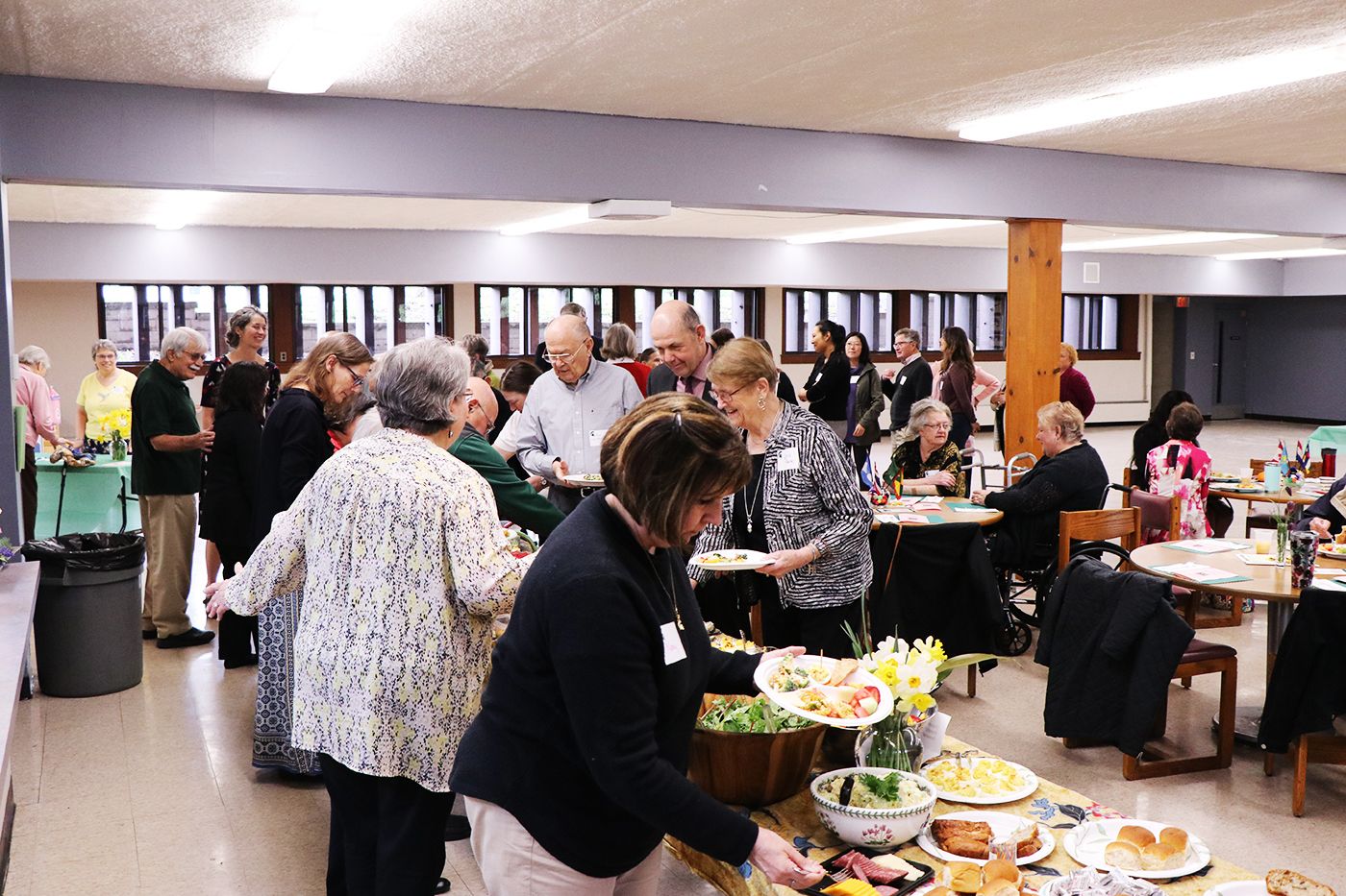 Volunteers with plates at buffet table. 