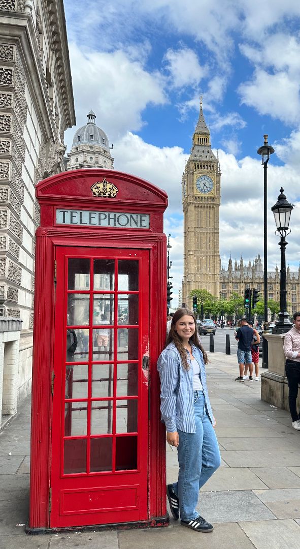 Emily standing next to iconic British red telephone booth with Big Ben in background