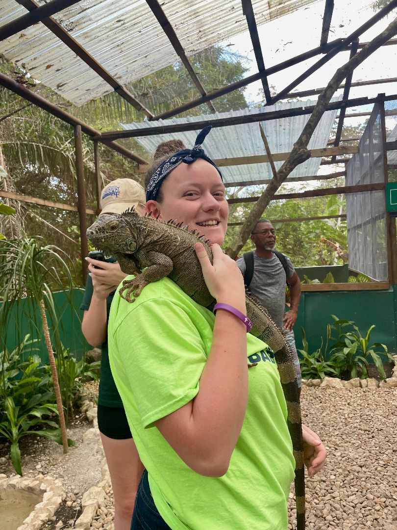 Summer holding an iguana on her shoulder in Belize