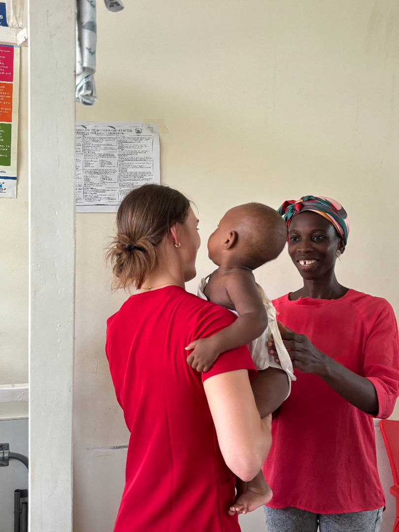 Anabeth holding a baby at a clinic in Ghana