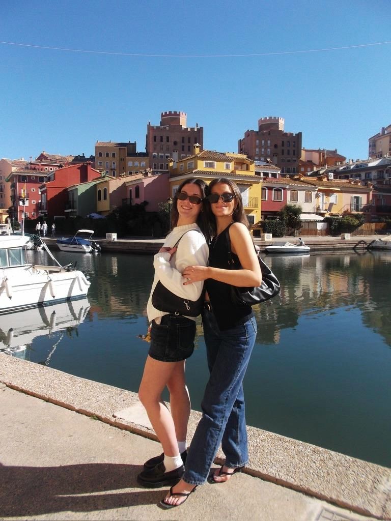 Avery and a friend posing on a dock with colorful building in the background