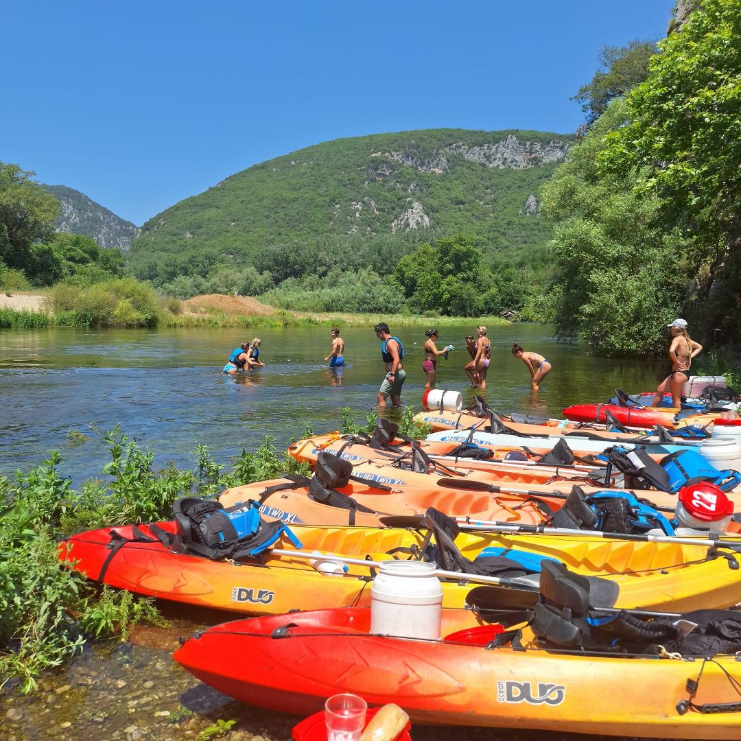 Students standing in river on a break from kayaking in Greece