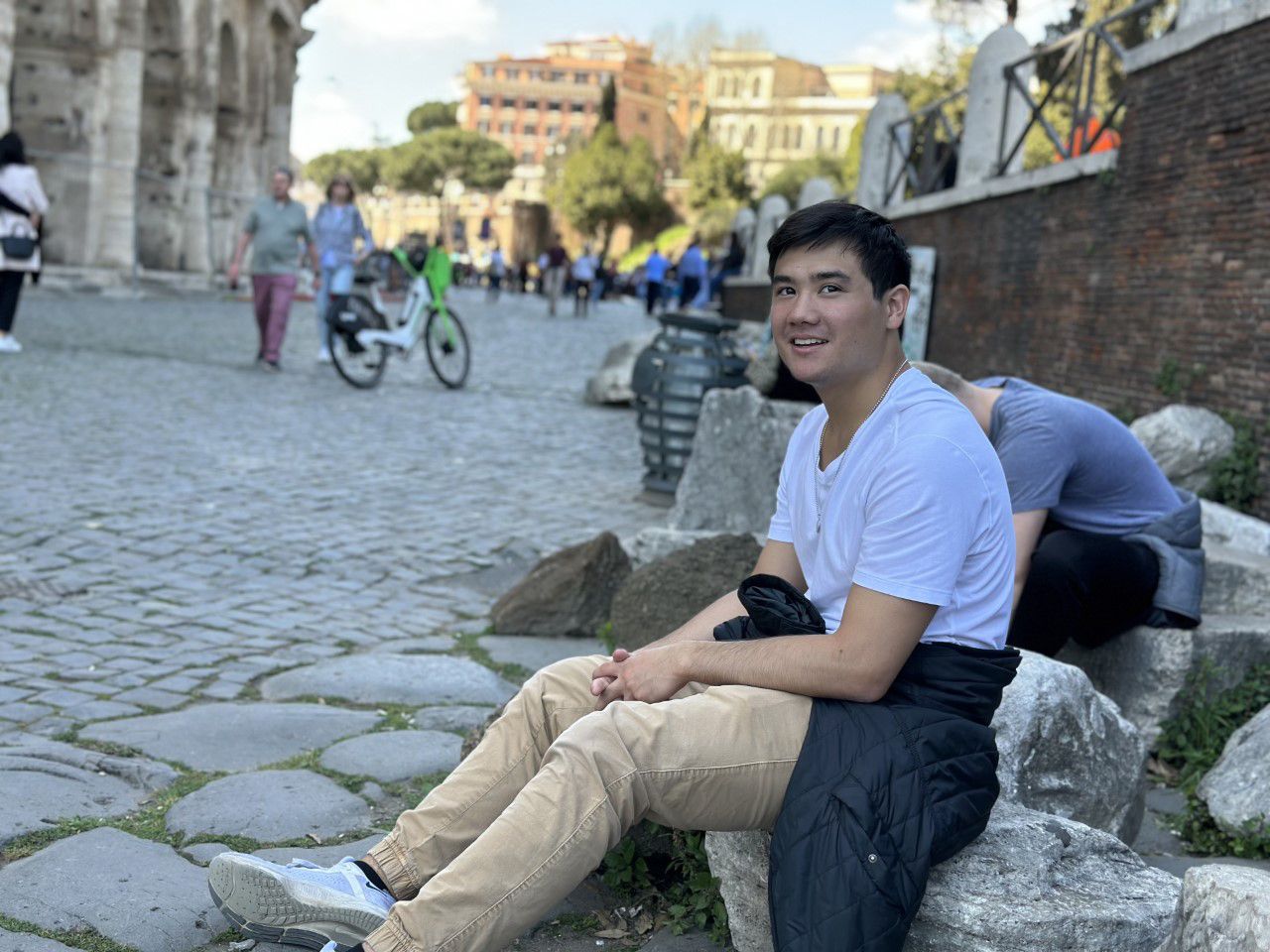 Nicholas sitting on cobblestone street in Rome Italy