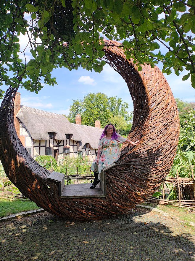 Julia sitting in straw globe in front of Globe Theatre