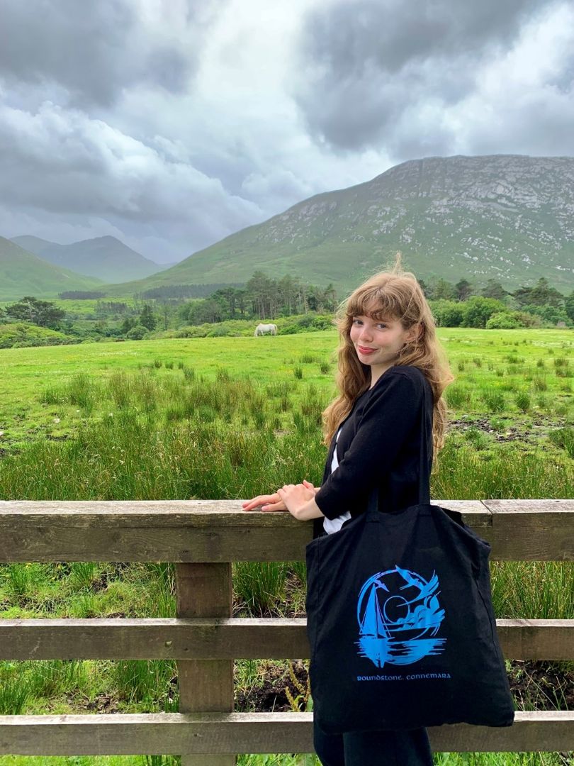Lilith posed by a fence with native Connemara ponies in the background at Kylemore Abbey.jpg