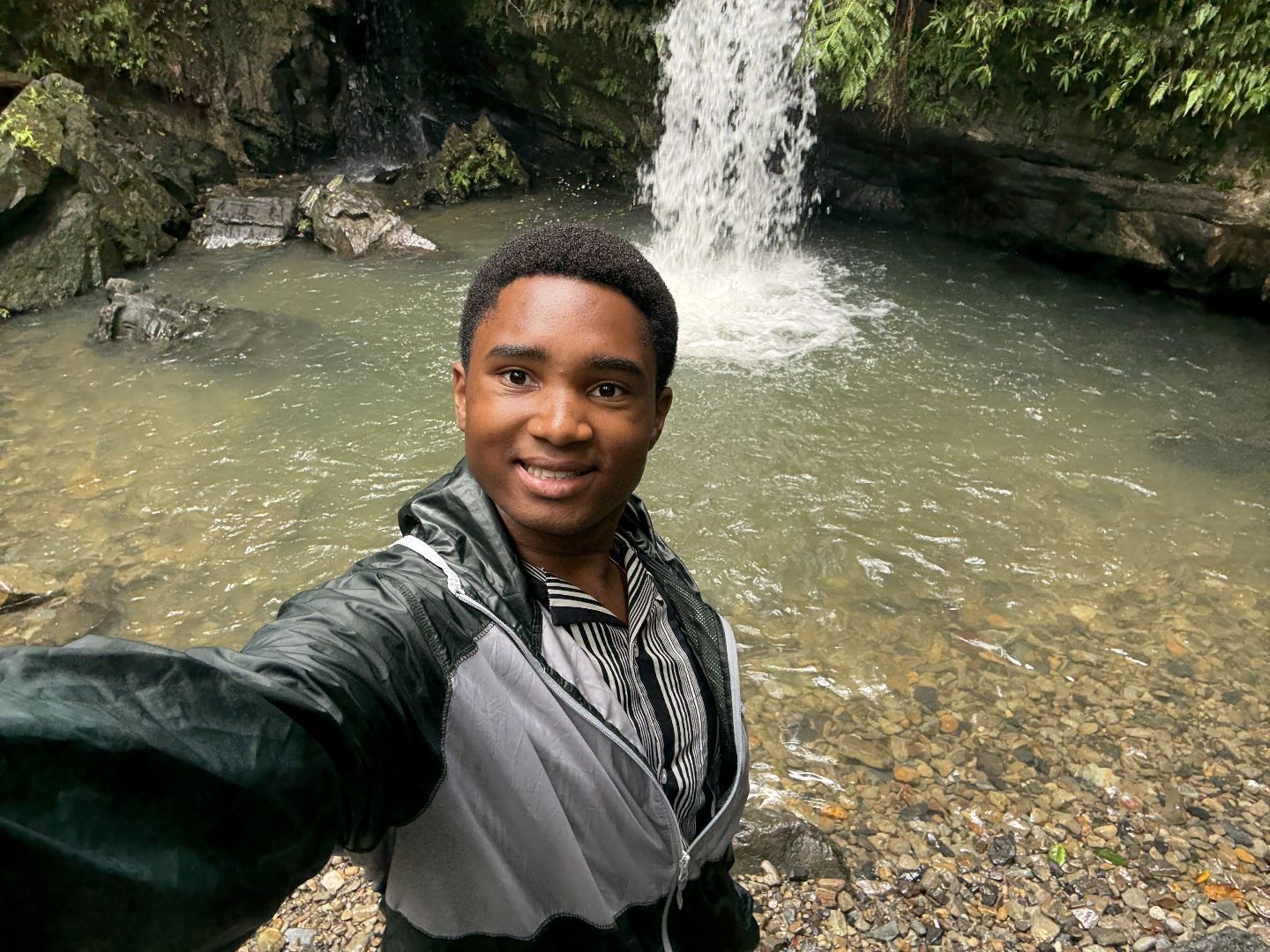 Joicen taking a selfie in front of a waterfall