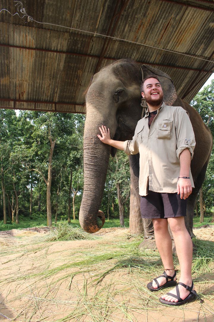 Zachary standing with elephant in Nepal