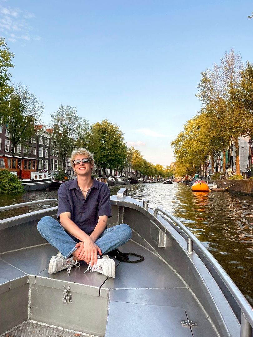 Alex sitting in a boat on a canal in Amsterdam