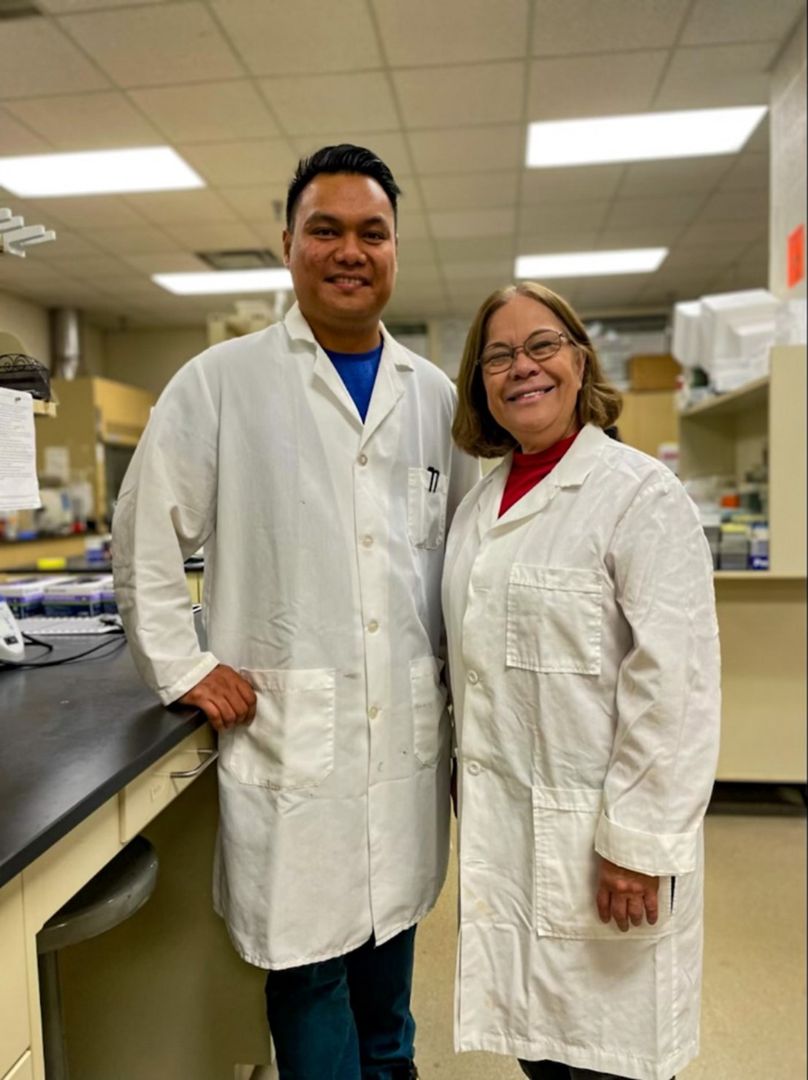 Image of a man and a woman wearing white lab coats standing in a laboratory