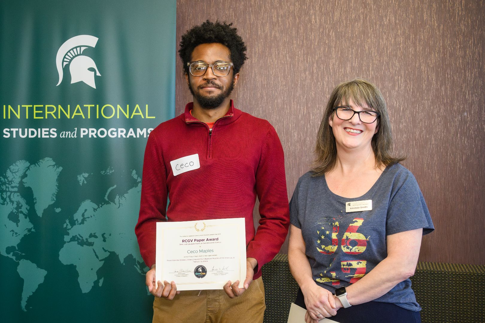 Ceco Maples posing with an award certificate with GenCen co-director Mindy Smith.