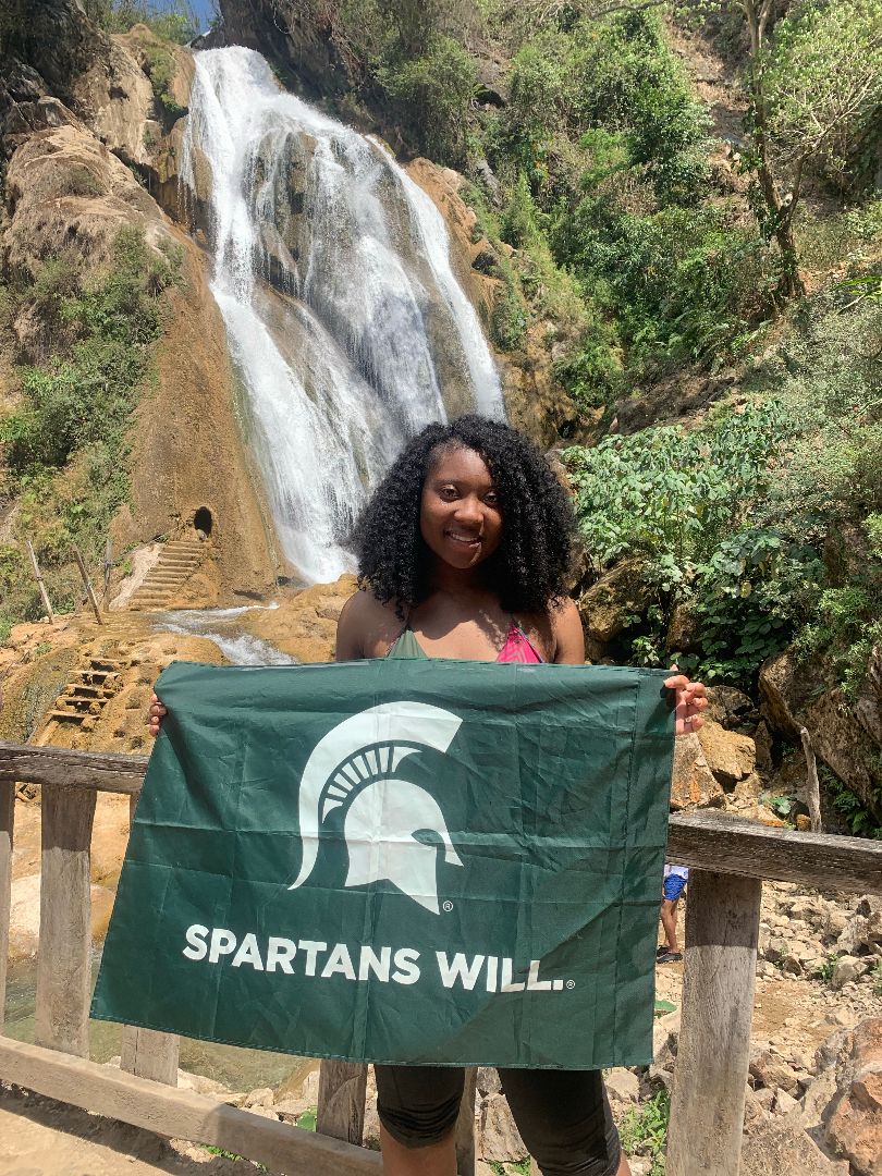 Toriona holding Spartan flag in front of a waterfall in Mexico