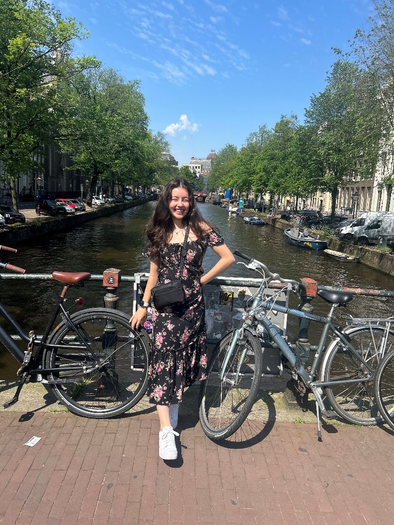 Lisa standing by bikes on a canal in Europe