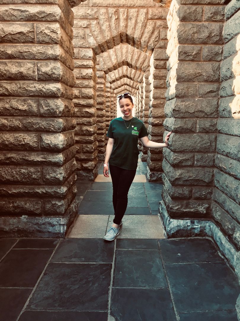 Sarah standing in hallway of stone columns in South Africa