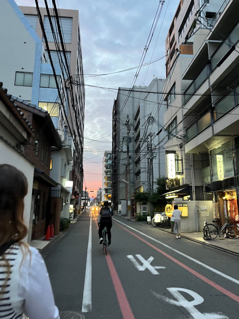 Person riding a bicycle down a narrow street in Japan