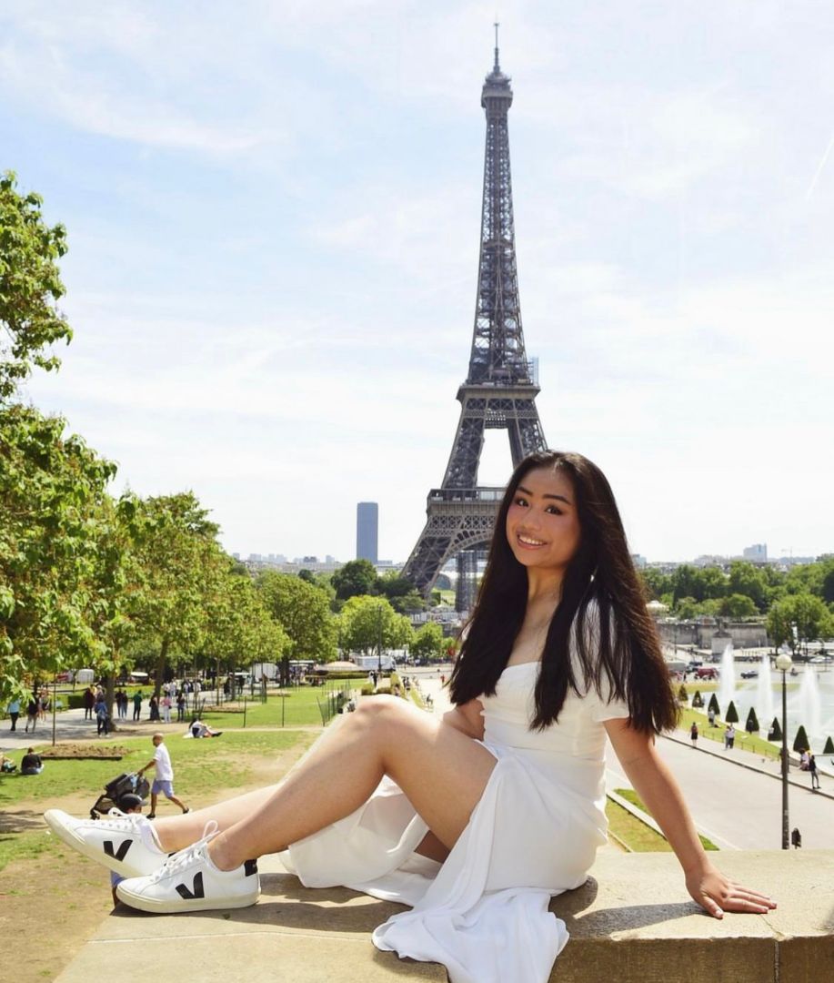 Leslie sitting on wall in front of Eiffel Tower in Paris